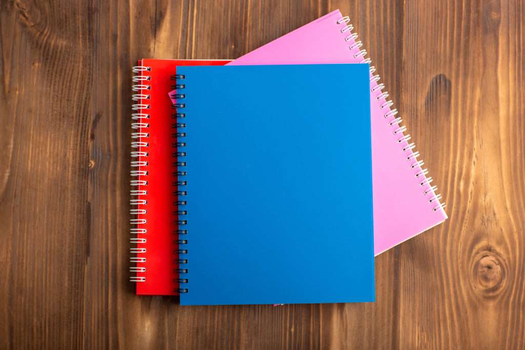 top-view-different-copybooks-colorful-ones-brown-desk