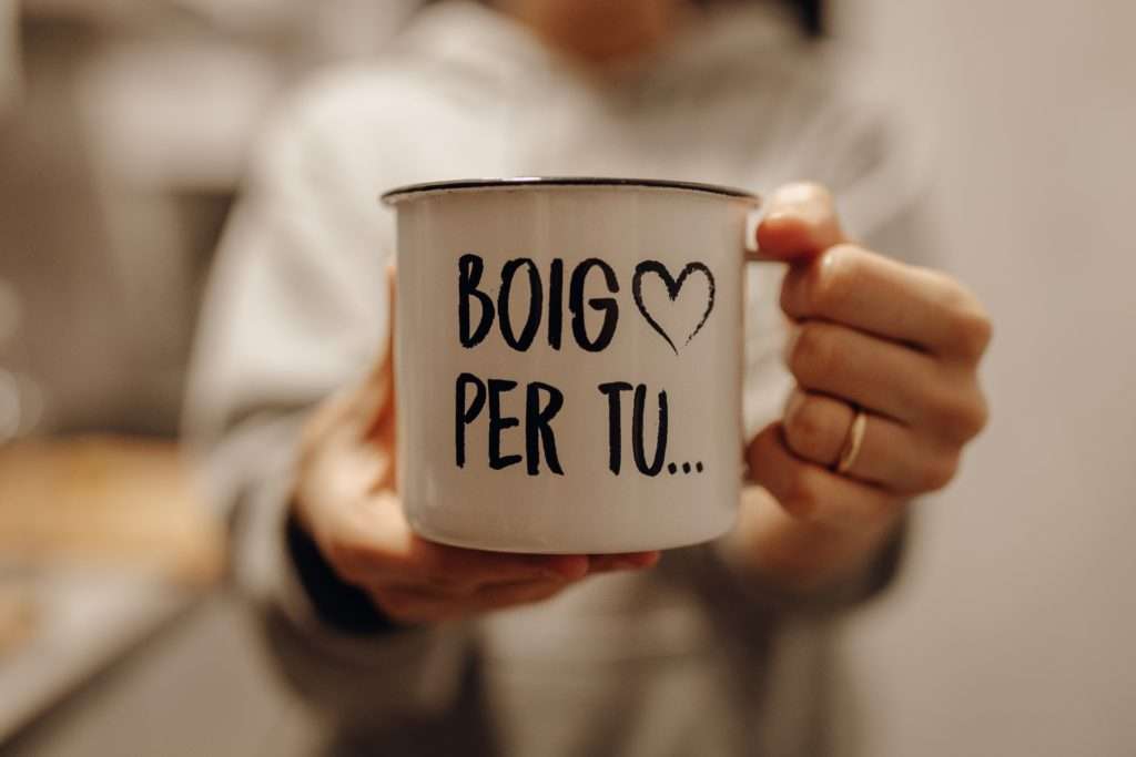 A closeup shot of a female holding a white ceramic mug with song lyrics printed on it
Translation: Crazy for you